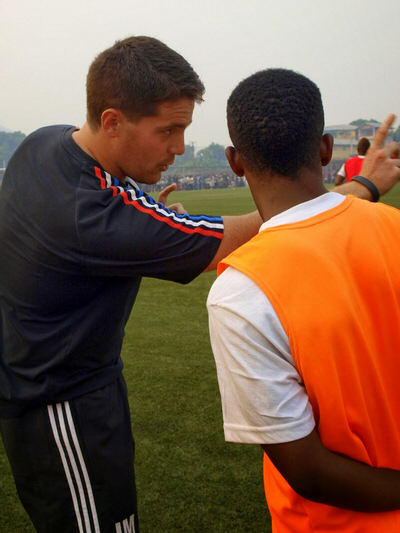 Coach McKinstry provides half time advice to Santigie Koroma (CBF) before his debut for Sierra Leone U20 [versus Guinea in 2015 CAF U-20 first round qualifying (Picture: Myrthe van Vliet)]